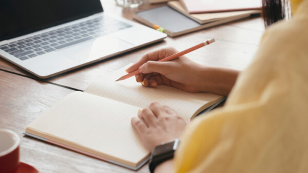 A person about to write in a blank notebook